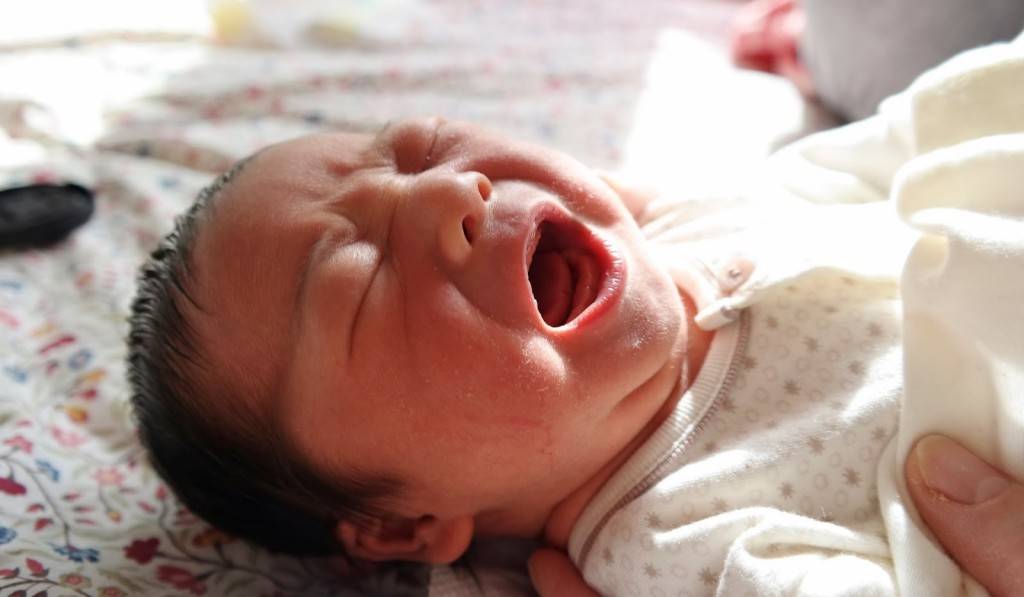 Новорожденный ребенок кряхтит, выгибается, плачет во сне и краснеет при этом