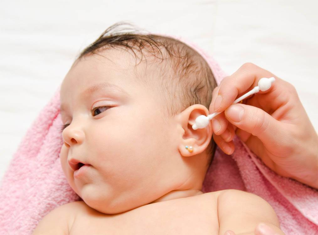Как чистить уши новорожденному, убирать корочки и опрелости